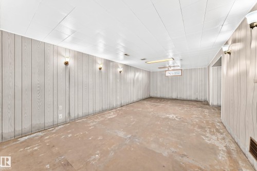 Spacious room featuring light-toned vertical paneling and a white plank ceiling - 10819 137 Avenue Nw, Edmonton, AB - Indoor Photo Showing Other Room