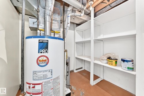 Utility area featuring a water heater and integrated shelving - 10819 137 Avenue Nw, Edmonton, AB - Indoor Photo Showing Basement
