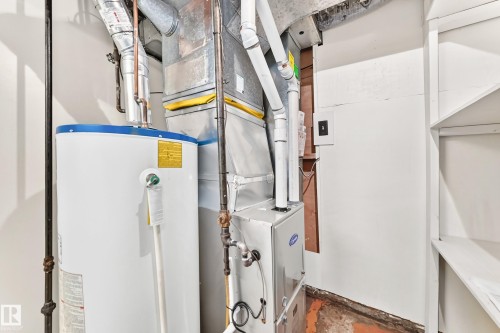 Utility space featuring a water heater, furnace, and exposed ductwork - 10819 137 Avenue Nw, Edmonton, AB - Indoor Photo Showing Basement