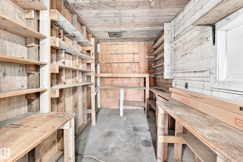 Utility space featuring extensive wood shelving, a concrete floor, and a wood-paneled ceiling - 10819 137 Avenue Nw, Edmonton, AB - Indoor