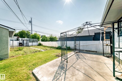 Expansive backyard featuring a concrete patio, a metal gazebo frame, and a chain-link fence - 10819 137 Avenue Nw, Edmonton, AB - Outdoor