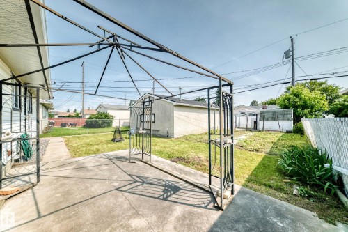 Poured concrete patio with a metal gazebo frame, extending to a concrete walkway - 10819 137 Avenue Nw, Edmonton, AB - Outdoor
