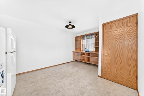 Built-in wood shelving and cabinetry with an integrated desk area - 10819 137 Avenue Nw, Edmonton, AB - Indoor Photo Showing Other Room