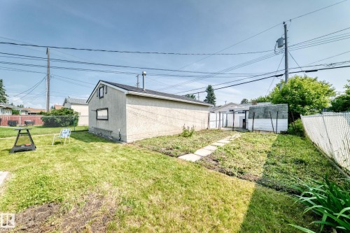 Detached garage with a pitched roof and stucco siding, featuring a small side window - 10819 137 Avenue Nw, Edmonton, AB - Outdoor