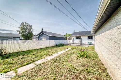 Spacious rear yard with a chain link fence and concrete path - 10819 137 Avenue Nw, Edmonton, AB - Outdoor