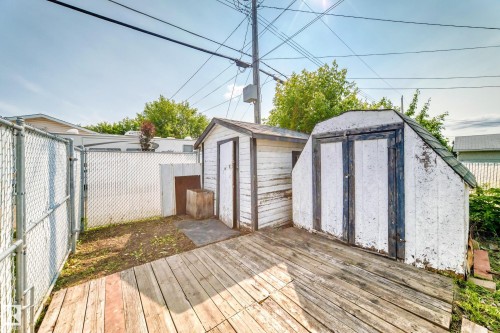 Deck area featuring two storage sheds, one with a gabled roof and double doors - 10819 137 Avenue Nw, Edmonton, AB - Outdoor With Deck Patio Veranda With Exterior