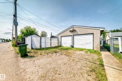 Detached garage with two roll-up doors and stucco exterior - 