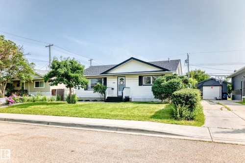 Single-story residence featuring white siding, black trim, and a dark roof - 10819 137 Avenue Nw, Edmonton, AB - Outdoor