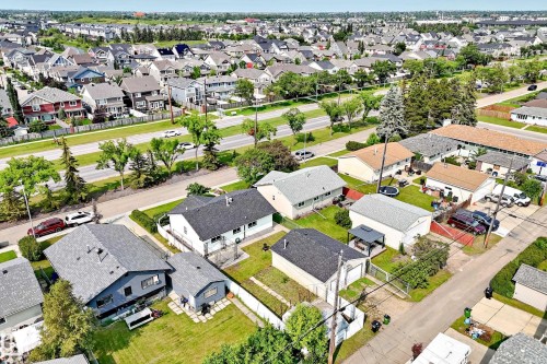 Aerial view showcasing a residential neighborhood with diverse housing styles, mature trees, and a multi-lane thoroughfare - 10819 137 Avenue Nw, Edmonton, AB - Outdoor With View