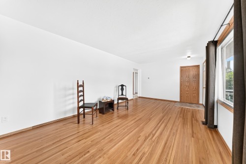 Hardwood flooring extends throughout this expansive room - 10819 137 Avenue Nw, Edmonton, AB - Indoor Photo Showing Other Room
