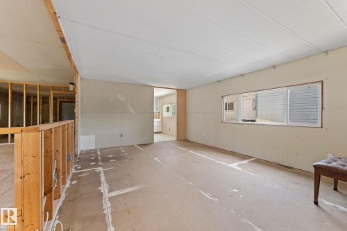 Open concept interior featuring exposed wood framing, a full-length window, and a light-colored ceiling - 219 Lee Ridge Road, Edmonton, AB - Indoor Photo Showing Other Room