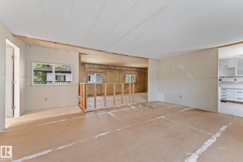 Interior space under renovation, featuring exposed drywall, a partial wall with wood framing, and existing window openings - 219 Lee Ridge Road, Edmonton, AB - Indoor