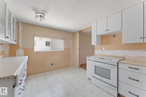 Kitchen featuring white cabinetry, a white electric range, and patterned linoleum flooring - 219 Lee Ridge Road, Edmonton, AB - Indoor Photo Showing Kitchen