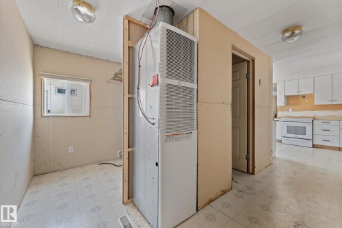 Utility space featuring a visible furnace unit, patterned floor covering, and a window with blinds - 219 Lee Ridge Road, Edmonton, AB - Indoor
