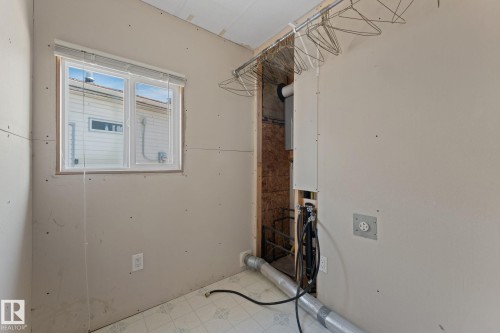 Utility space featuring a window with horizontal blinds, exposed wall studs, and utility hookups - 219 Lee Ridge Road, Edmonton, AB - Indoor