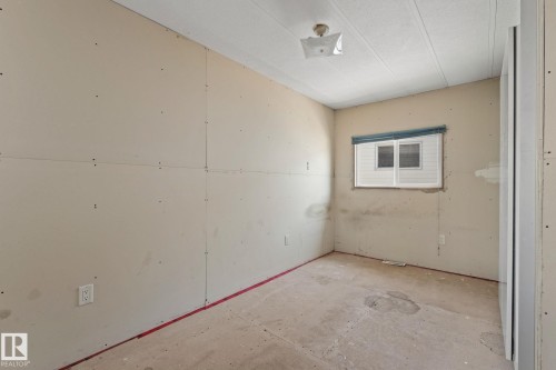 Interior room showcasing unfinished drywall, a single window with blinds, and a ceiling-mounted light fixture - 219 Lee Ridge Road, Edmonton, AB - Indoor Photo Showing Other Room