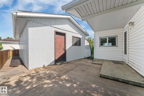 Concrete patio area featuring a detached utility building with a brown door and a window - 219 Lee Ridge Road, Edmonton, AB - Outdoor With Exterior