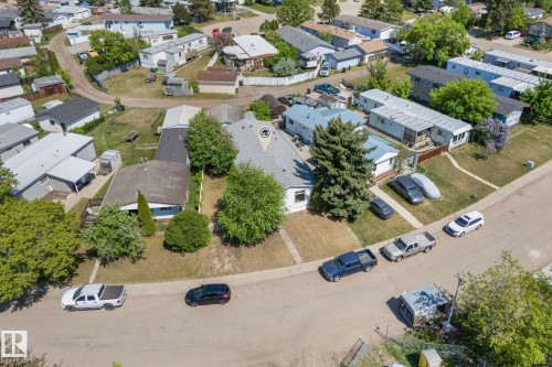Residential street featuring a single-story property with a grey shingle roof, mature trees, and a front yard with green lawn - 219 Lee Ridge Road, Edmonton, AB - Outdoor With View