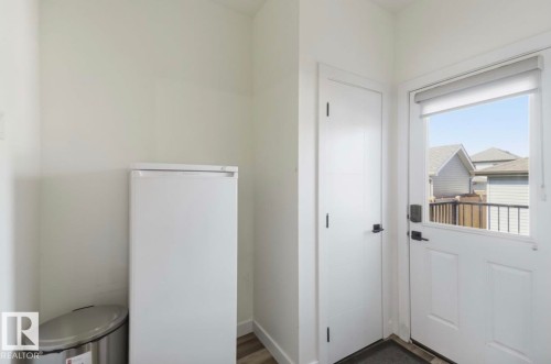 Entryway featuring a white paneled door with integrated glass, a matching interior door, and wood-finish flooring - 17924 61 Street Nw, Edmonton, AB - Indoor Photo Showing Other Room