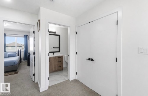 Hallway featuring plush carpet flooring, white walls, and contemporary black hardware on doors - 17924 61 Street Nw, Edmonton, AB - Indoor