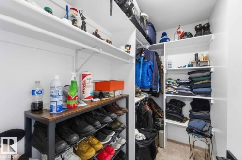 Walk-in closet featuring white built-in shelving, hanging rods, and a carpeted floor - 17924 61 Street Nw, Edmonton, AB - Indoor With Storage