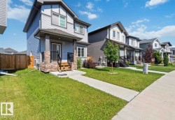 Contemporary two-story residence with light blue siding and dark gray trim - 