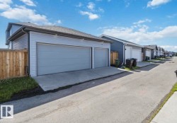 Two-car garage with light gray overhead doors, light gray siding, and a concrete driveway - 