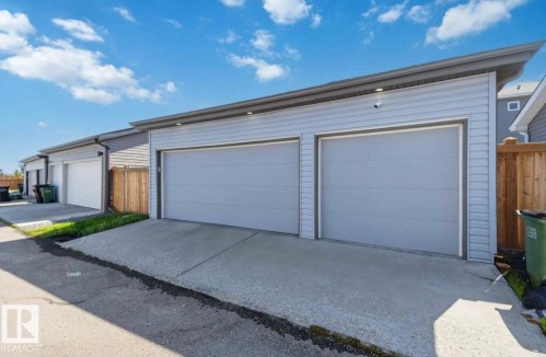 Detached two-car garage featuring light gray horizontal panel siding and concrete driveways - 17924 61 Street Nw, Edmonton, AB - Outdoor