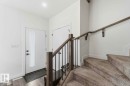 Entryway featuring a contemporary white door with frosted glass panel, matte black hardware, and wood-finish flooring - 17924 61 Street Nw, Edmonton, AB  - Indoor Photo Showing Other Room 