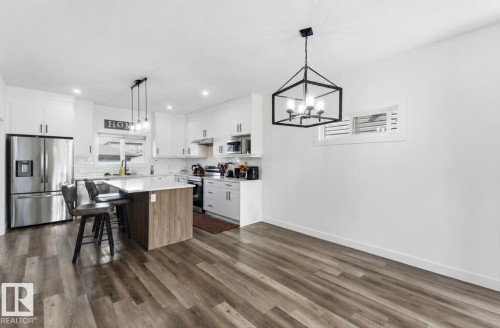 Open-concept kitchen and dining area featuring wood-finish flooring - 17924 61 Street Nw, Edmonton, AB - Indoor Photo Showing Kitchen With Stainless Steel Kitchen With Upgraded Kitchen
