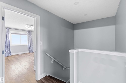 Upper landing featuring gray wall tones, recessed lighting, and a white balustrade - #64 120 Magrath Rd Nw, Edmonton, AB - Indoor Photo Showing Other Room