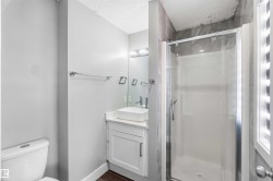Modern bathroom featuring a glass-enclosed shower with tile surround, white floating vanity with vessel sink, and chrome fixtures - 