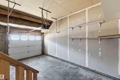 Attached garage featuring a white sectional door with upper window panels - #64 120 Magrath Rd Nw, Edmonton, AB - Indoor Photo Showing Garage