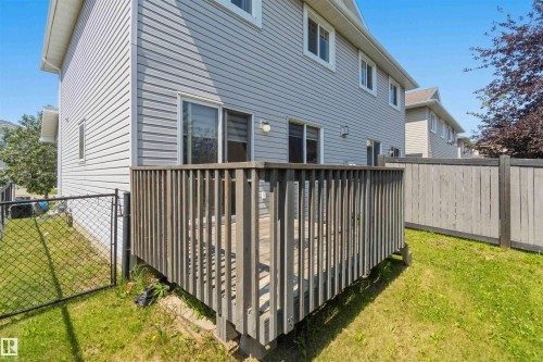 Outdoor deck with a wood railing and a sliding glass door entry to the home - #64 120 Magrath Rd Nw, Edmonton, AB - Outdoor With Exterior