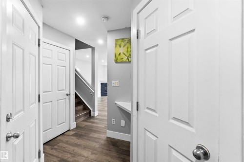 Hallway featuring wood-finish flooring, white paneled doors, and recessed lighting - #64 120 Magrath Rd Nw, Edmonton, AB - Indoor Photo Showing Other Room