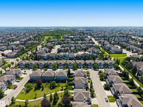 Expansive residential neighborhood featuring numerous detached and attached properties with green spaces and established landscaping - #64 120 Magrath Rd Nw, Edmonton, AB - Outdoor With View