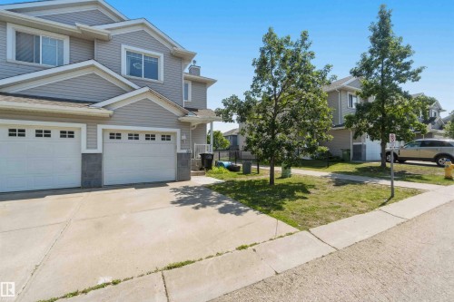 Two-story residence featuring light gray siding, white trim, and a concrete driveway - #64 120 Magrath Rd Nw, Edmonton, AB - Outdoor With Facade