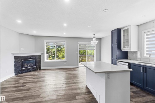 Open-concept living space with wood-finish flooring - #64 120 Magrath Rd Nw, Edmonton, AB - Indoor With Fireplace