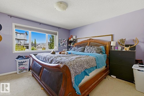 Spacious room featuring a large window, light-colored carpeting, a ceiling-mounted light fixture, and a neutral wall color - 3724 163 Avenue Nw, Edmonton, AB - Indoor Photo Showing Bedroom