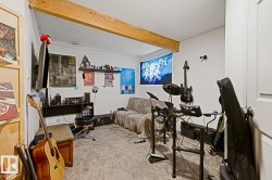 Room featuring exposed wood beams, recessed lighting, white walls, and gray carpeting - 
