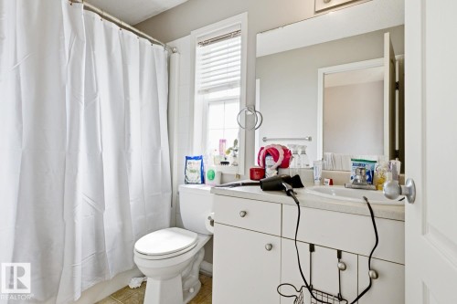 Bathroom featuring a single vanity with storage cabinetry, an integrated sink, and a rectangular mirror - 3724 163 Avenue Nw, Edmonton, AB - Indoor Photo Showing Bathroom