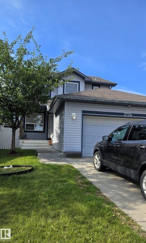Two-story property featuring light blue siding with dark trim accents and a shingled roof - 3724 163 Avenue Nw, Edmonton, AB - Outdoor