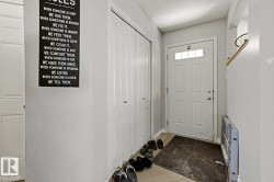 Entryway featuring a white paneled door with glass inserts, light grey wall paint, and wood-finish flooring - 