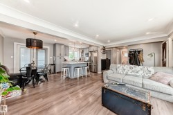 Open-concept living space featuring wood-finish flooring, recessed lighting, and crown molding - 