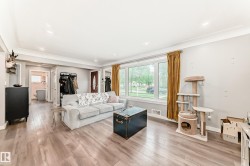 Spacious living area featuring wood-finish flooring, recessed lighting, and a prominent picture window with a street view - 