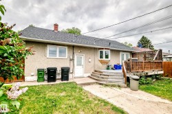 Rear exterior featuring stucco siding, a shingled roof, and a wooden deck with lattice detailing - 