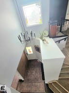 Foyer featuring a modern chandelier, decorative front door with transom window, and wood-finish flooring - 