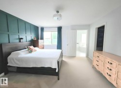 Bedroom featuring a dark teal accent wall with vertical and horizontal paneling - 