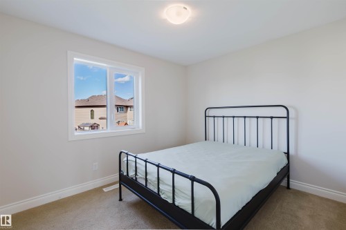 Windowed room featuring neutral wall tones, carpeted flooring, and a flush-mount ceiling light fixture - 17348 6 Avenue Nw, Edmonton, AB - Indoor Photo Showing Bedroom
