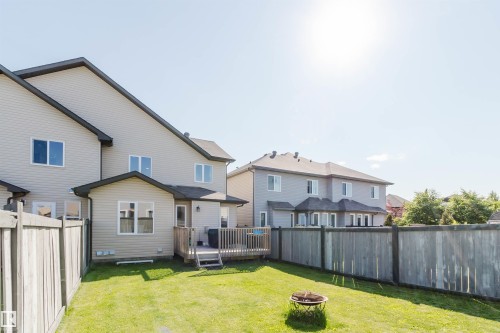 Expansive backyard featuring a manicured lawn, wood fencing, and a built-in deck with steps - 17348 6 Avenue Nw, Edmonton, AB - Outdoor With Deck Patio Veranda